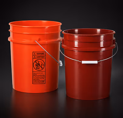 Two red plastic buckets with metal handles against a black background.