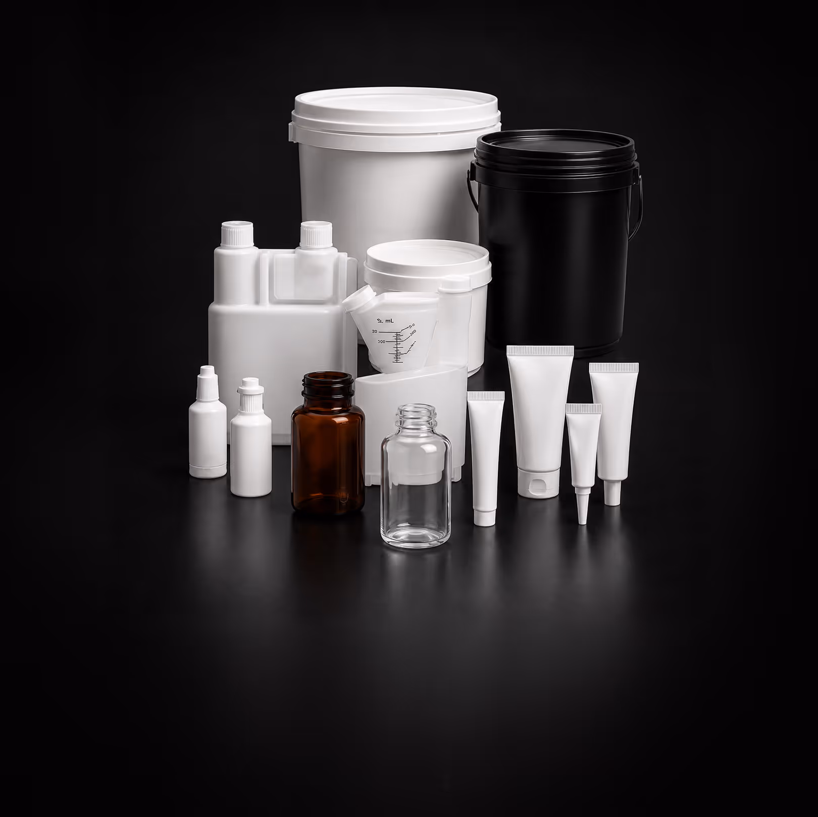 Various white, black, brown plastic and glass containers and tubes on black surface.
