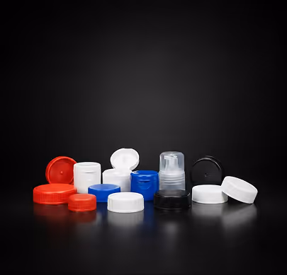 Various red, blue, black, and white plastic bottle caps and lids on a black surface.