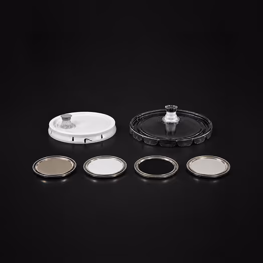 Four watch crystals and two watch crystal holders on black background.