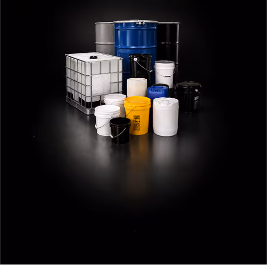 Various metal and plastic barrels and containers of different sizes on a black surface.