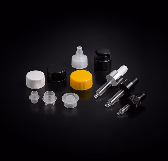 Various plastic bottle caps and dropper tops in white, black, yellow, and clear on a black background.