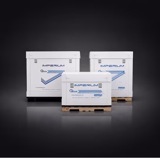 White Imperium shipping crates of various sizes on wooden pallets against black background.