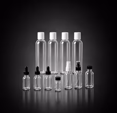 Set of empty clear plastic bottles with varied caps including droppers and spray tops on black background.