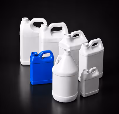 Group of seven plastic jugs in various sizes, one blue and six white, on a black surface.
