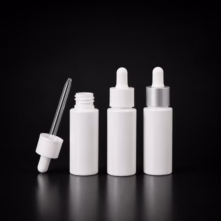 Three white dropper bottles on black background, one with dropper removed and placed beside it.