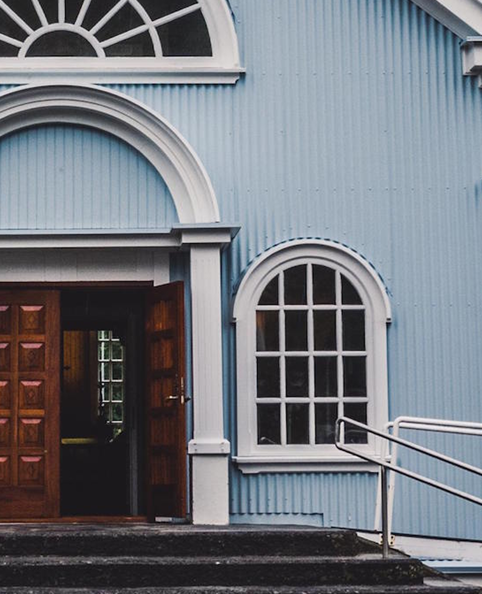 Photo of a blue church with open doors