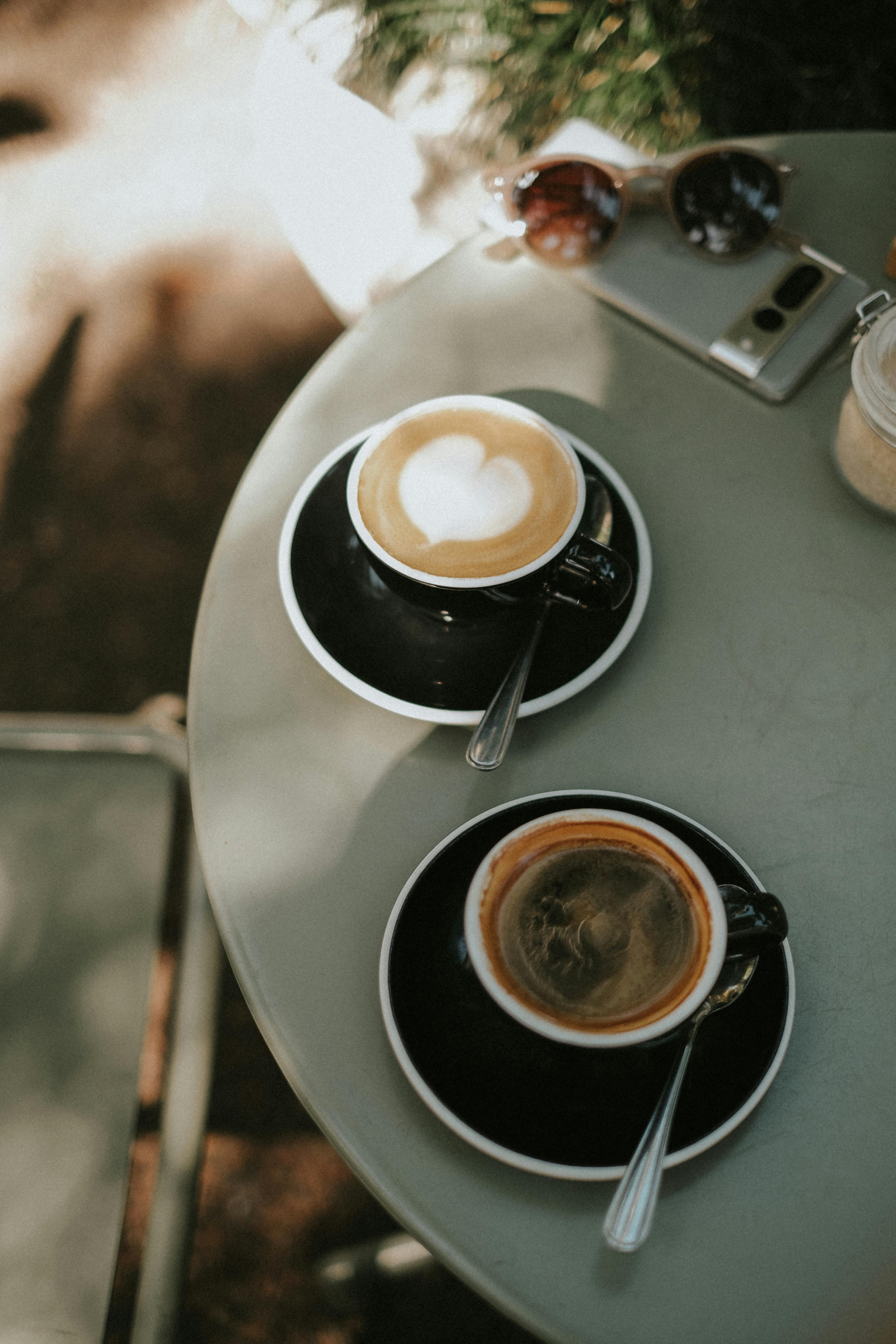 Two cups of coffee on a shaded table