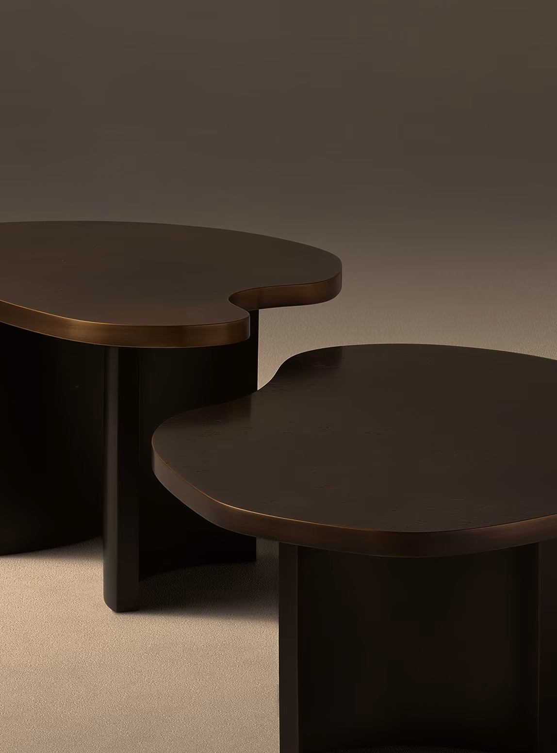 Two dark brown wooden tables with rounded, asymmetrical tops and matching cylindrical bases placed on a light-colored surface.