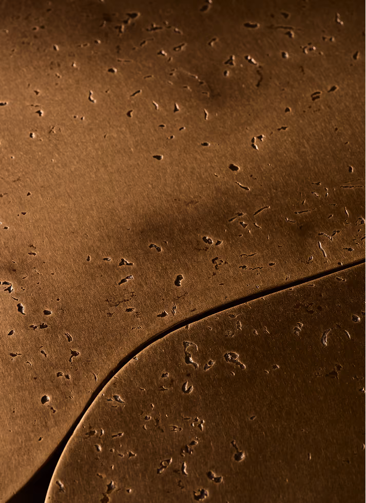 Close-up of brown cork material with natural irregular holes and textured surface.