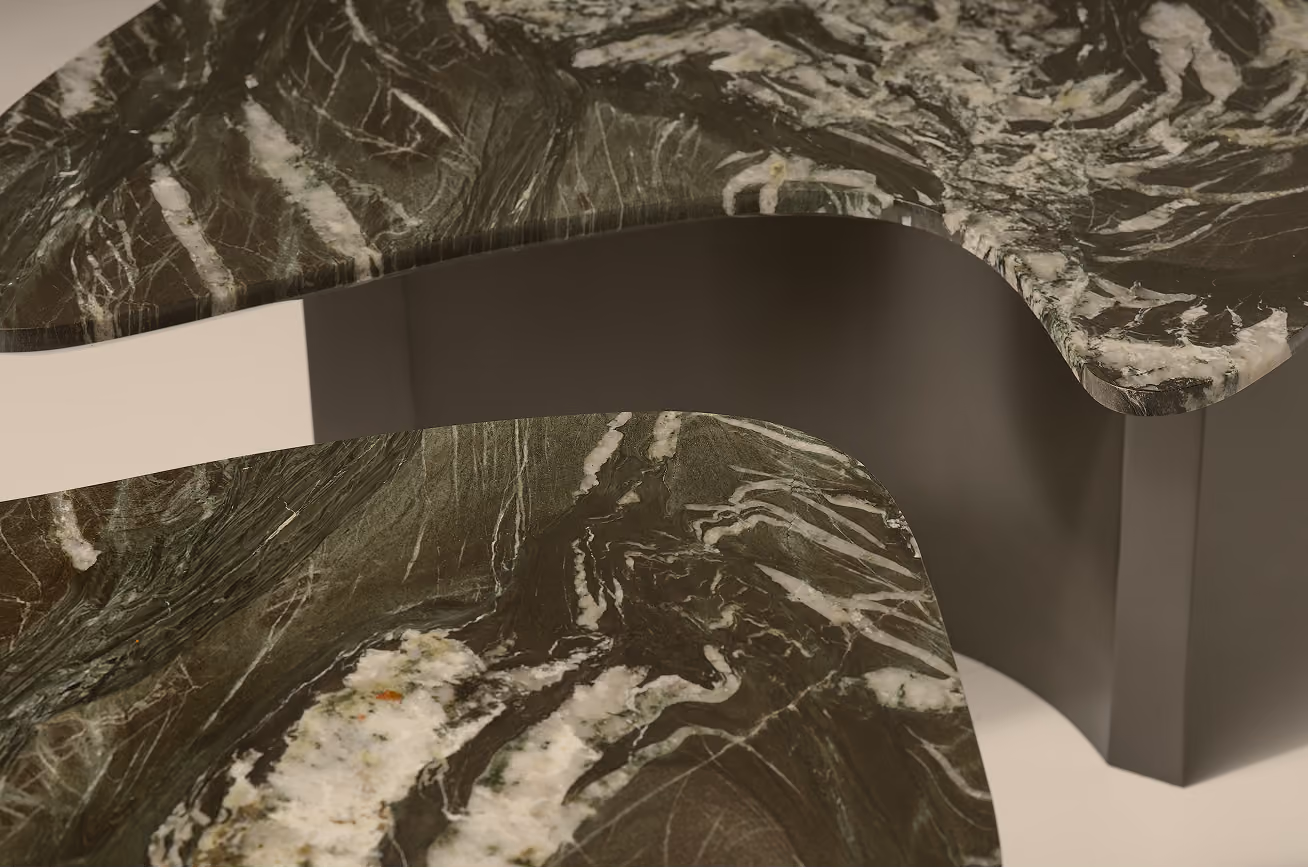 Close-up of two overlapping surfaces with dark green and white marble patterns and smooth curved edges.