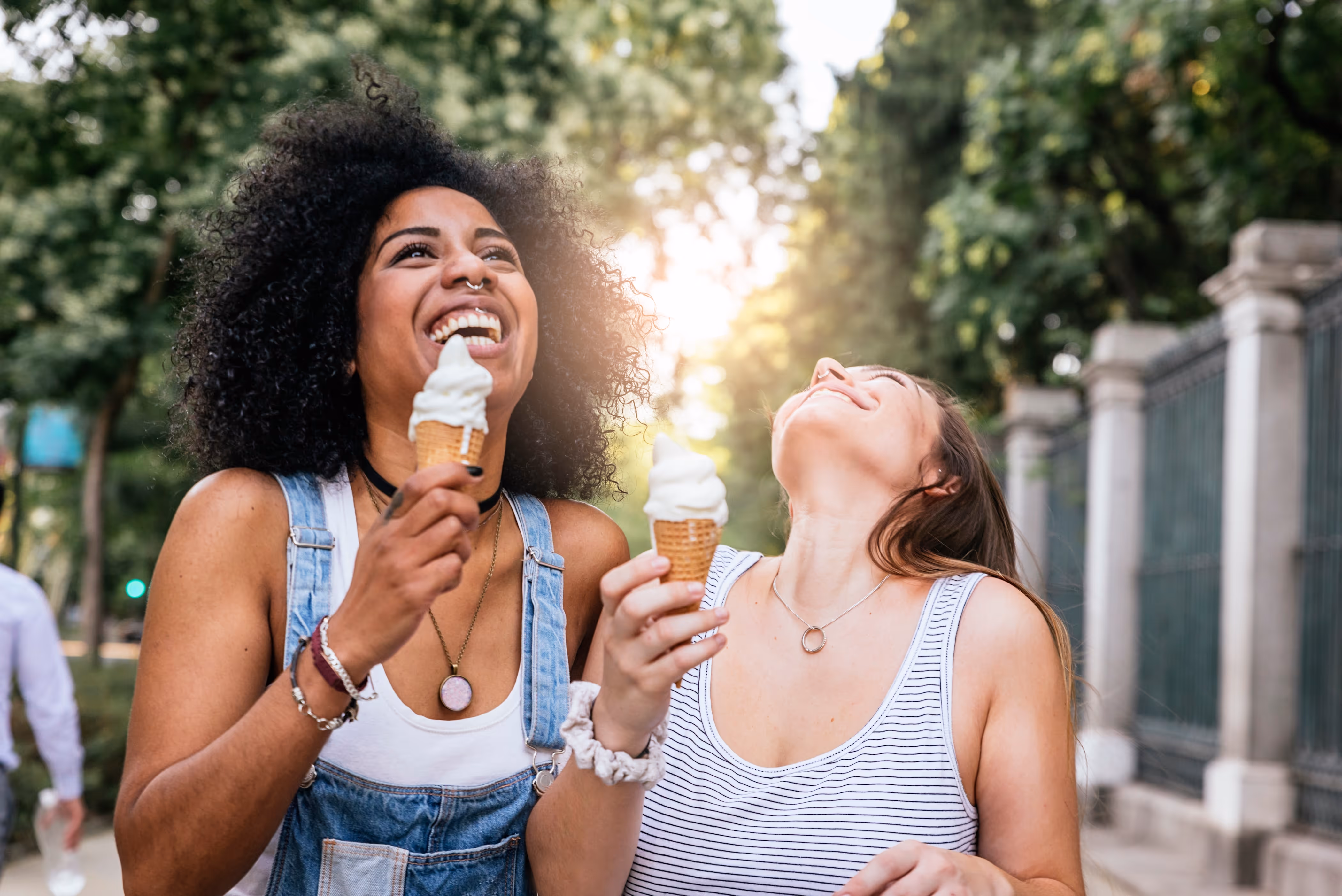Two women holding ice cream laughing stock image