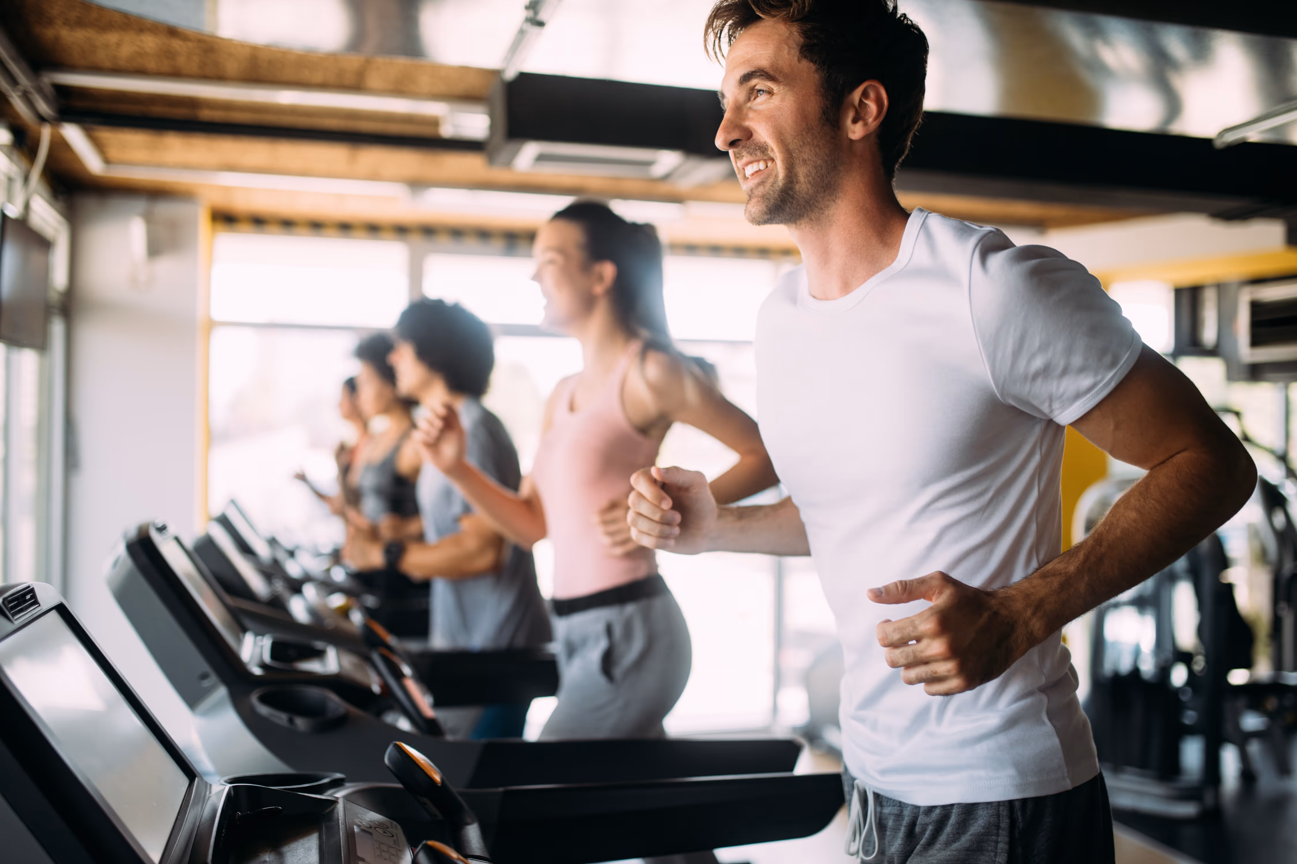 Man and woman running on treadmill stock image
