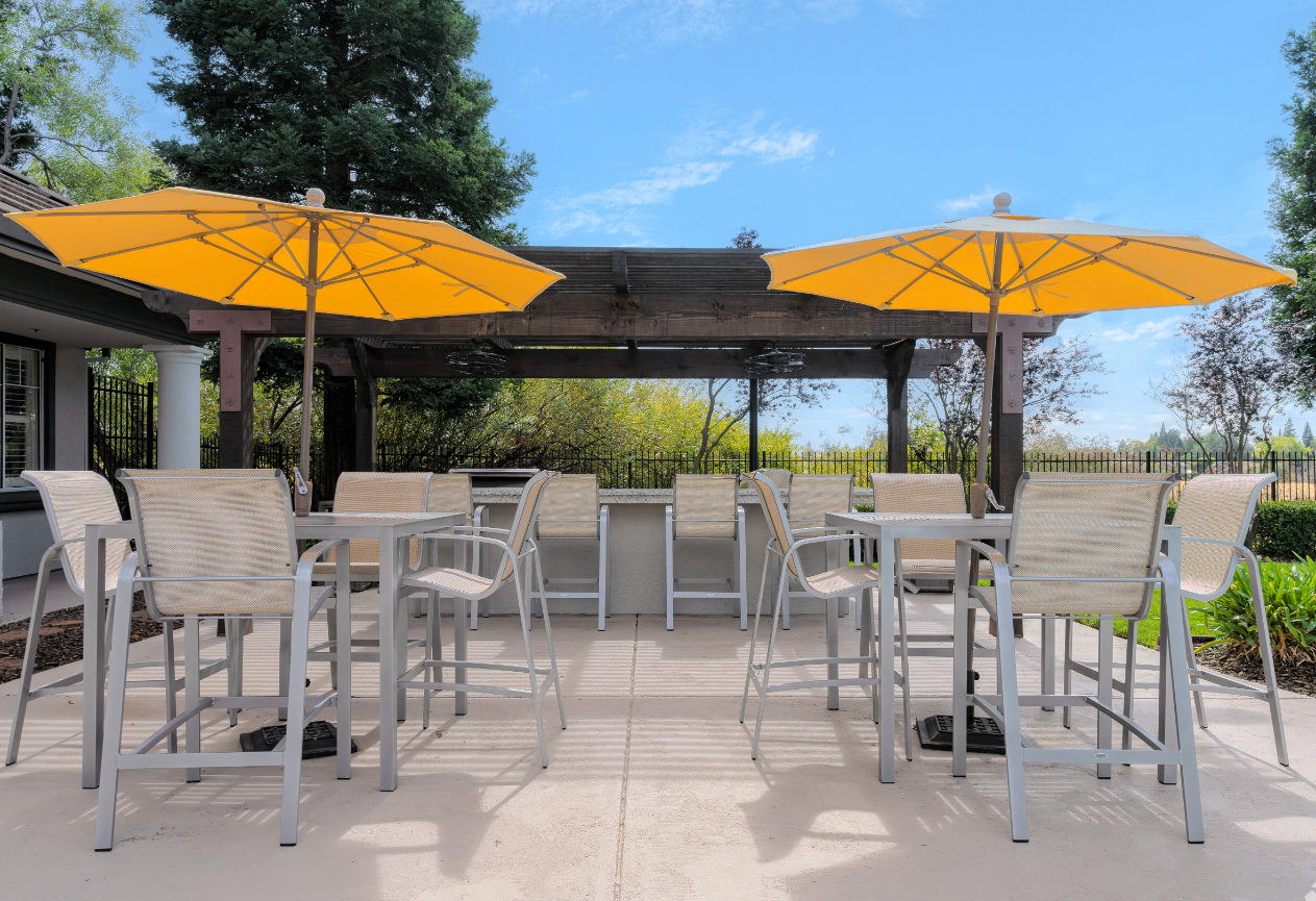 BBQ area with tables, chairs, and umbrellas