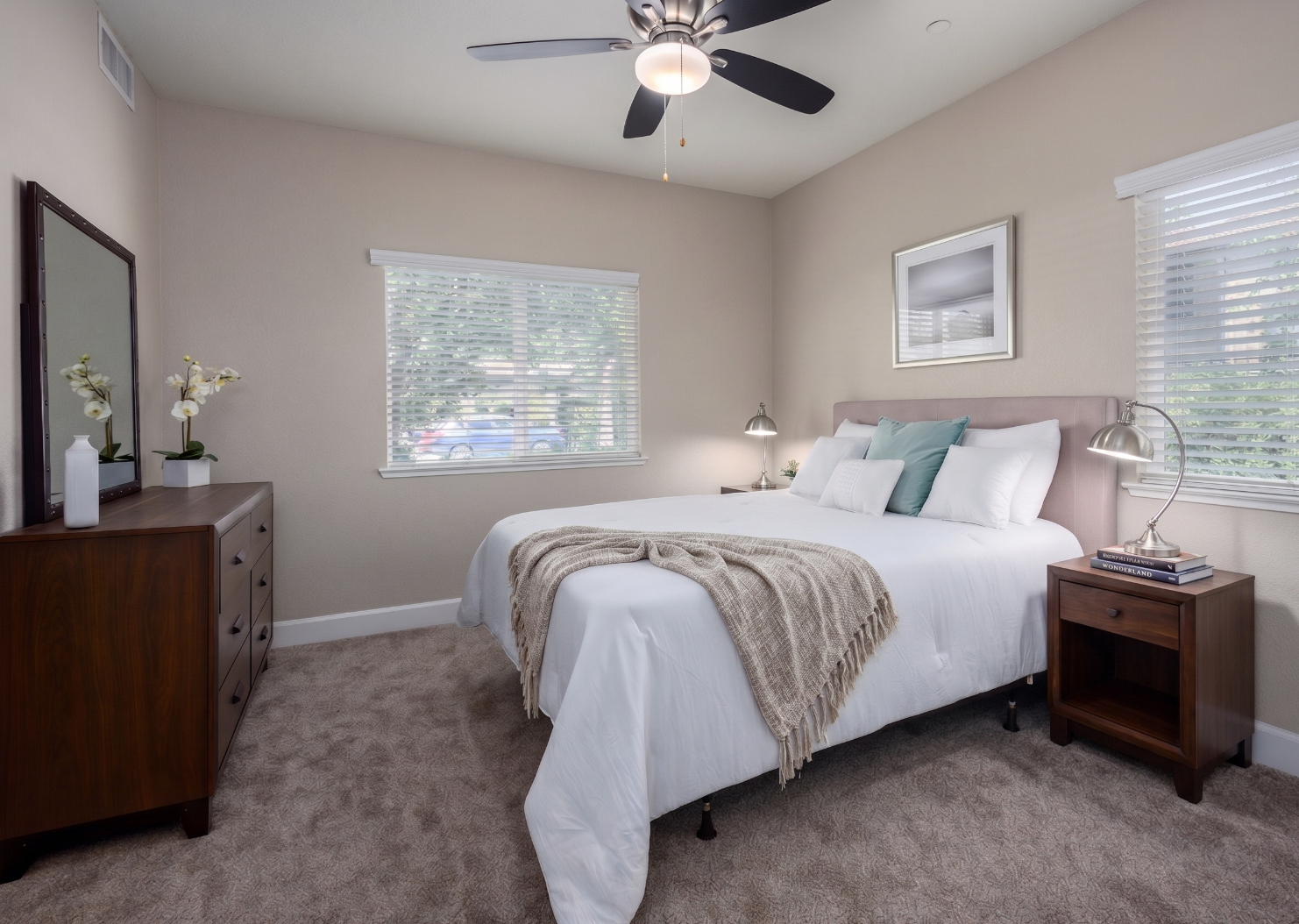 Bedroom with bed, lamp, dresser, and large window
