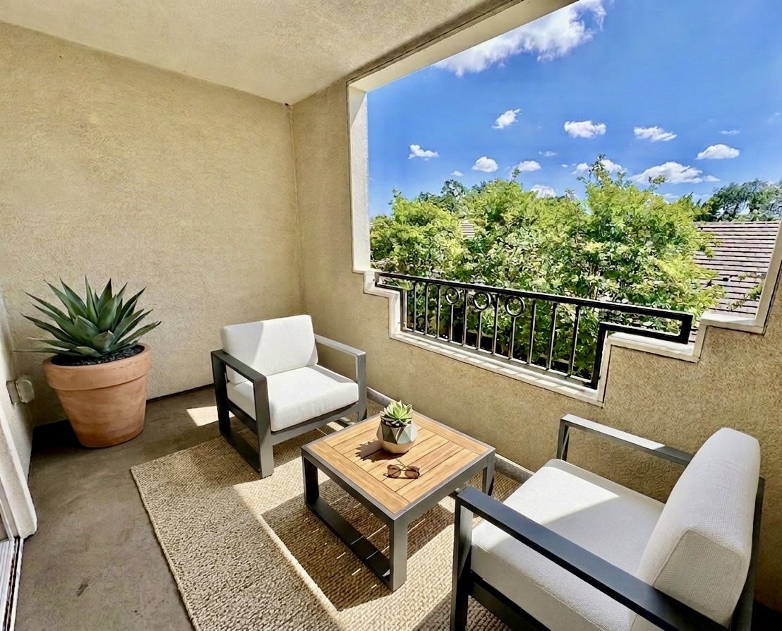 Balcony exterior with chairs coffee table, and plant