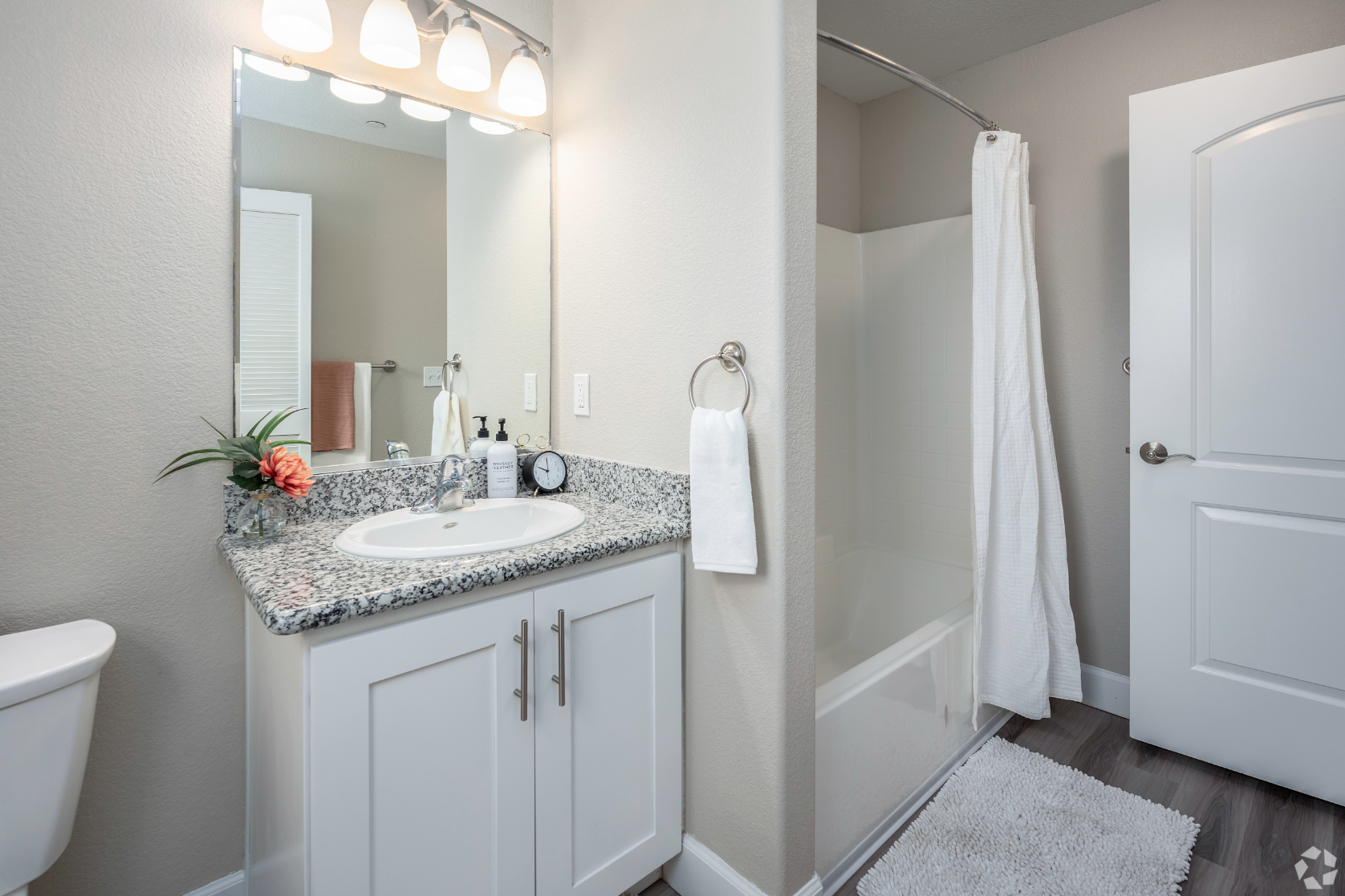Bathroom with vanity and white cabinets with shower tub combo