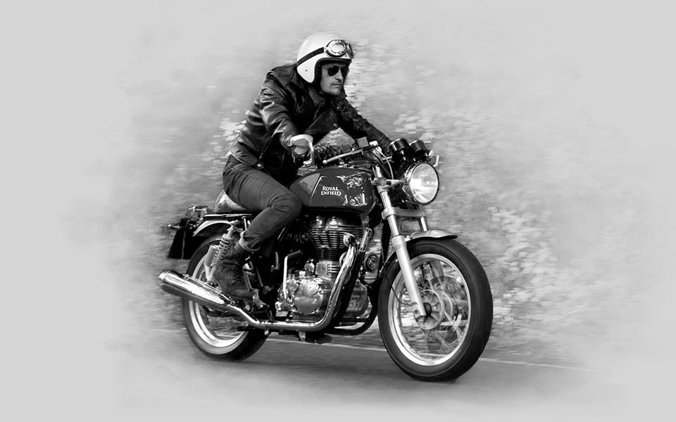 Jezdec v kožené bundě a otevřené přilbě na motocyklu Royal Enfield Continental GT 535