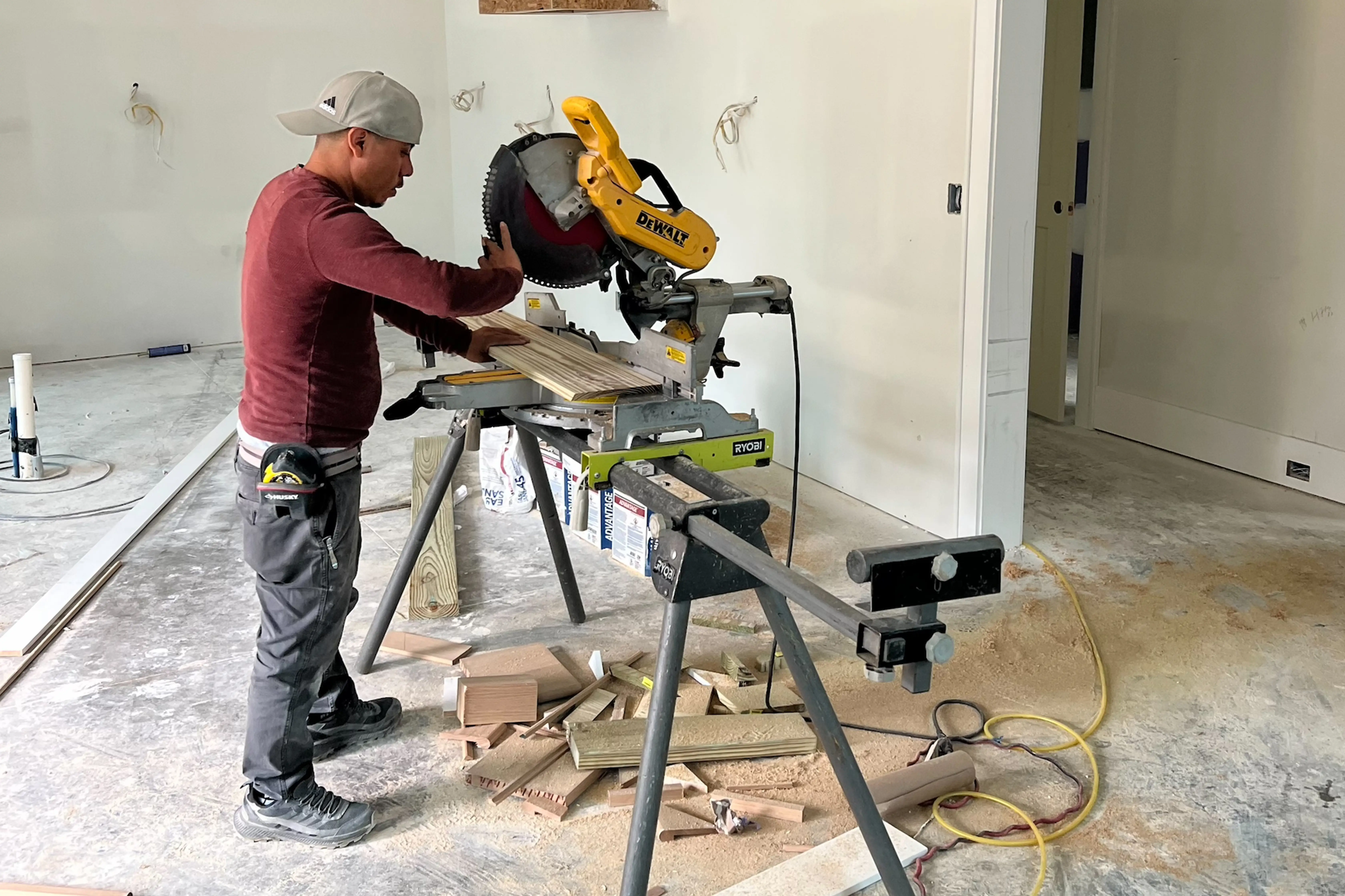 photo of a man cutting wood inside a home