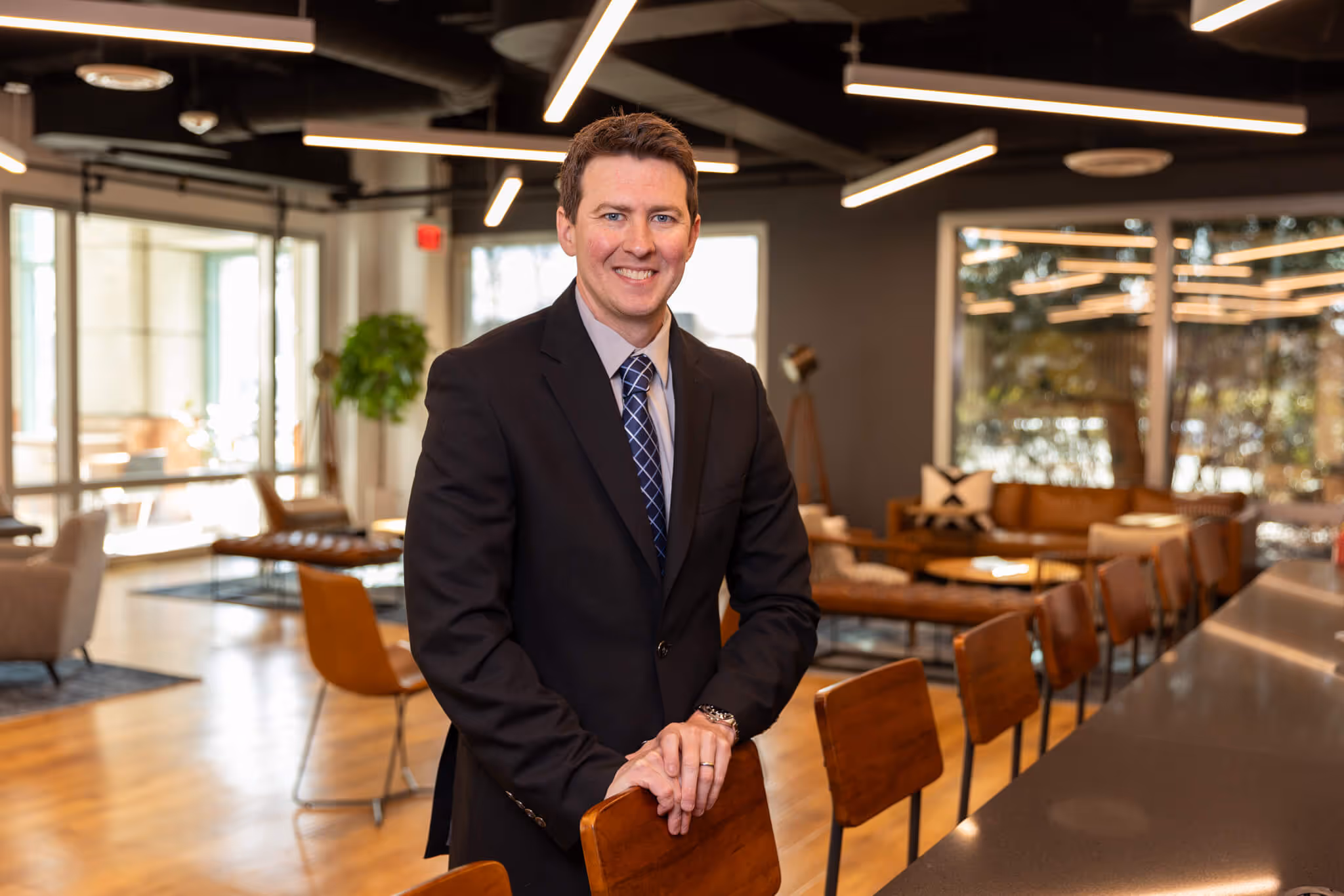 William Keller, MBA in a board room wearing a black suit with a blue tie