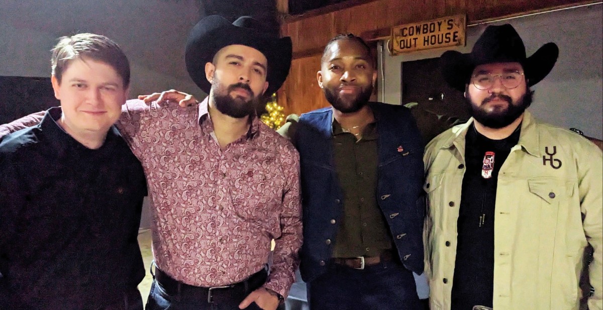 CNF members posing together at Cowboy's Out House in western attire and hats