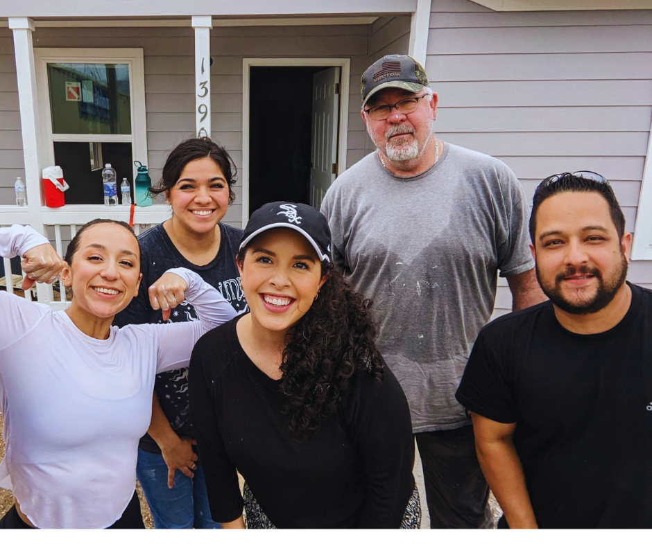 CNF Team posing together in front of a residential house with light gray siding.
