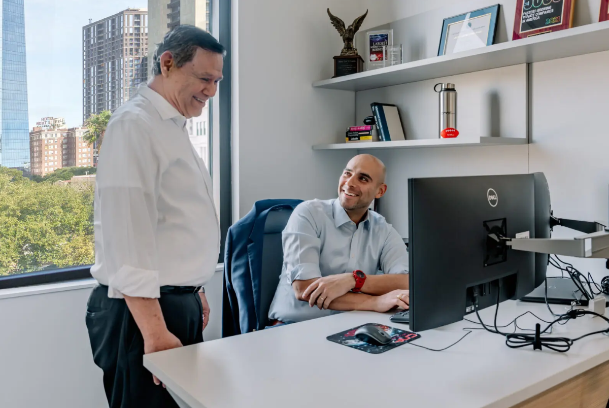 Fred and Freddy smiling and talking in an office