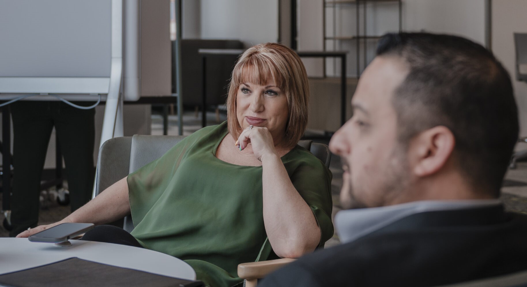 Lisa and Jason engaged in a business meeting discussion at a conference table.