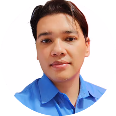 Headshot of a man with short dark hair wearing a blue collared shirt, looking at the camera with a neutral expression.