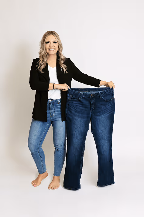 Photo of Carrie holding up her "Before-Sized" pants