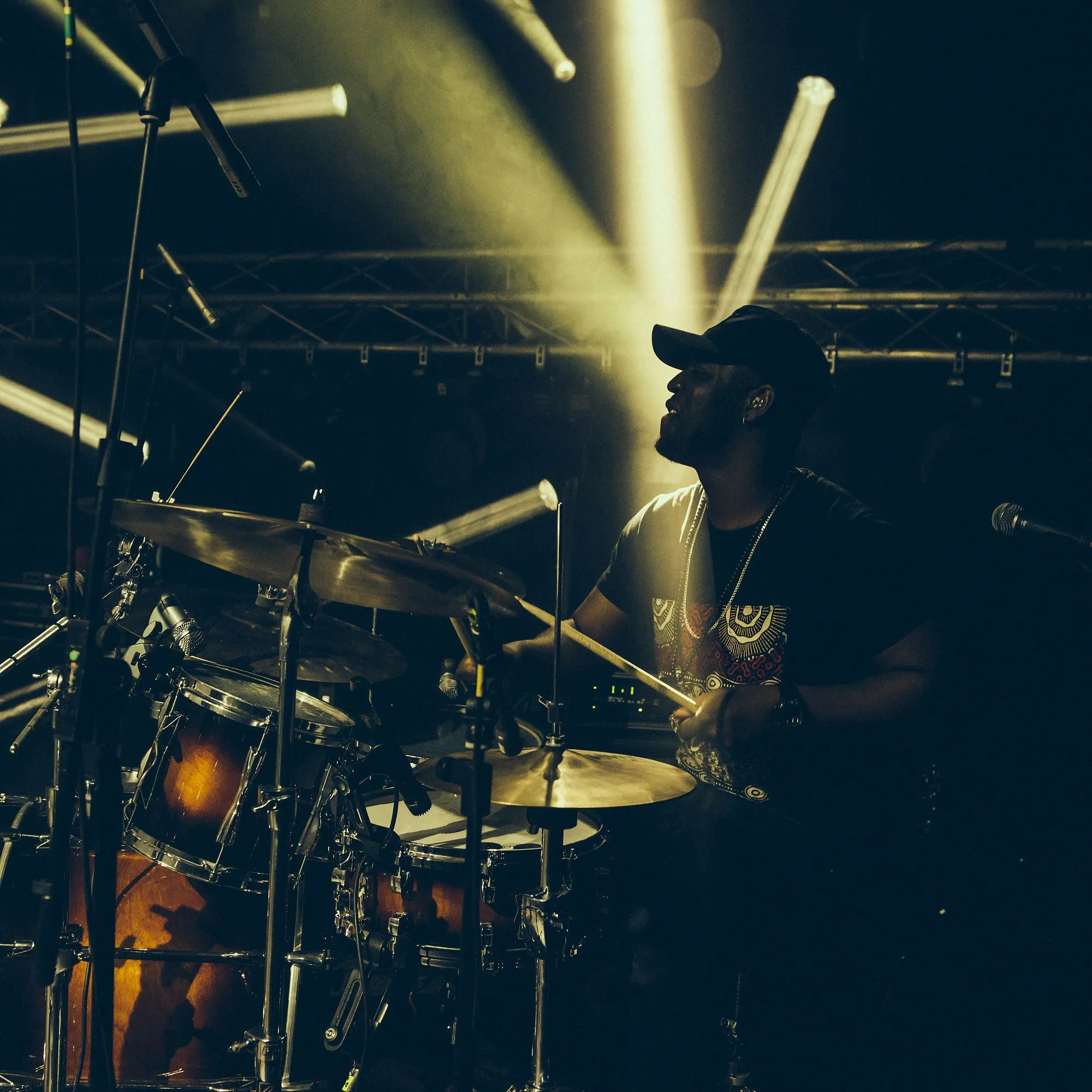Drummer silhouetted by dramatic concert lighting