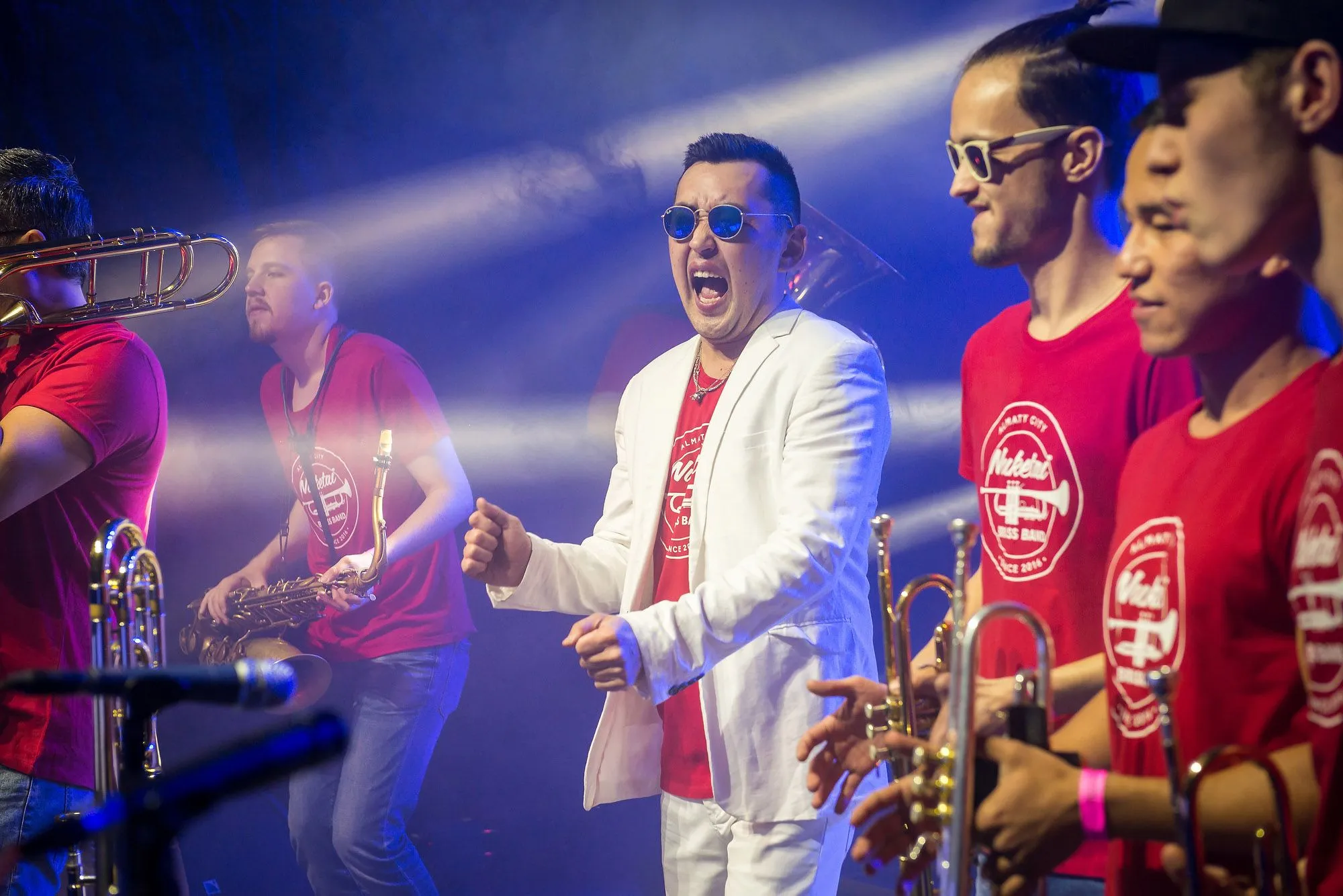 Singer and brass section captured together during an energetic live performance
