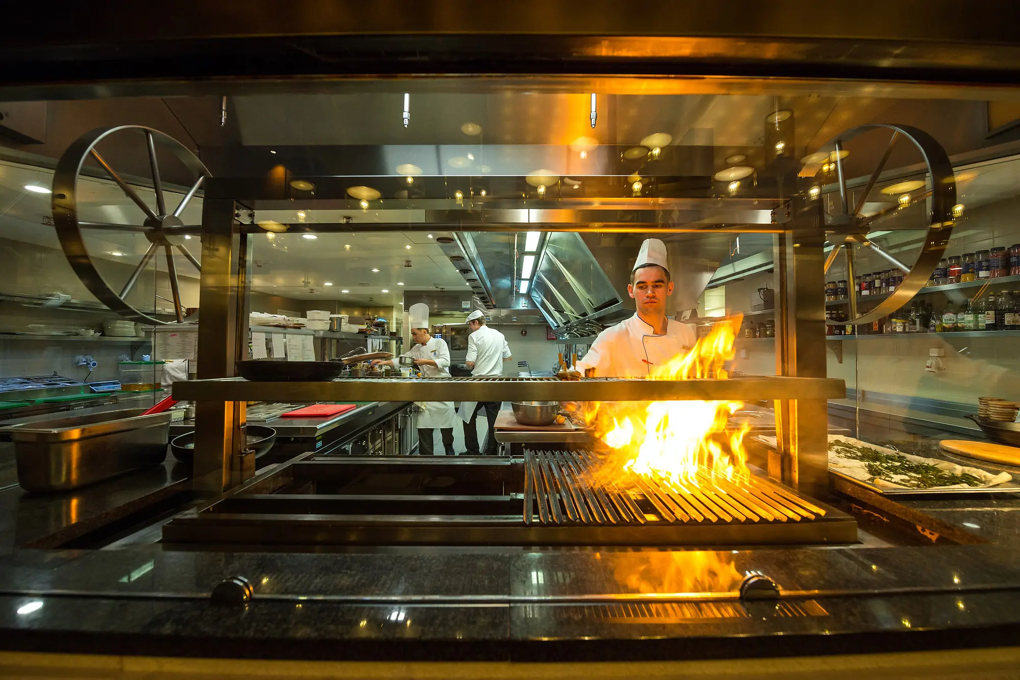 Chef working with open flame in a commercial kitchen