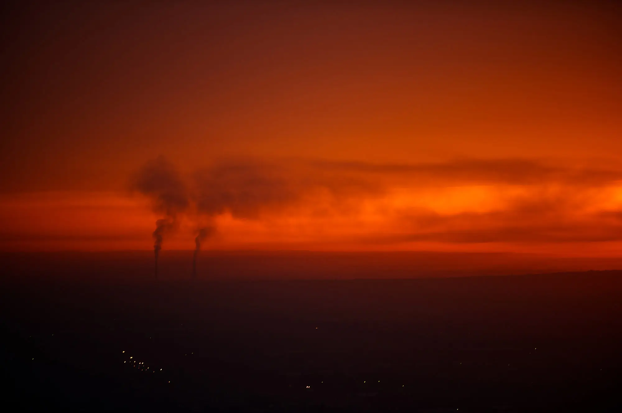 Film production crew silhouetted against an orange location sunset