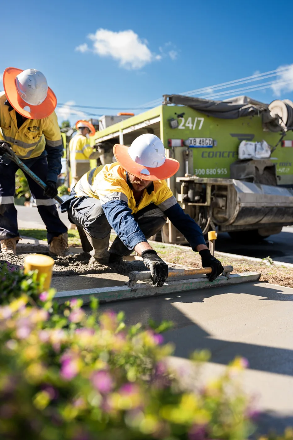 Concrete Taxi crew finishing concrete beside their branded delivery truck