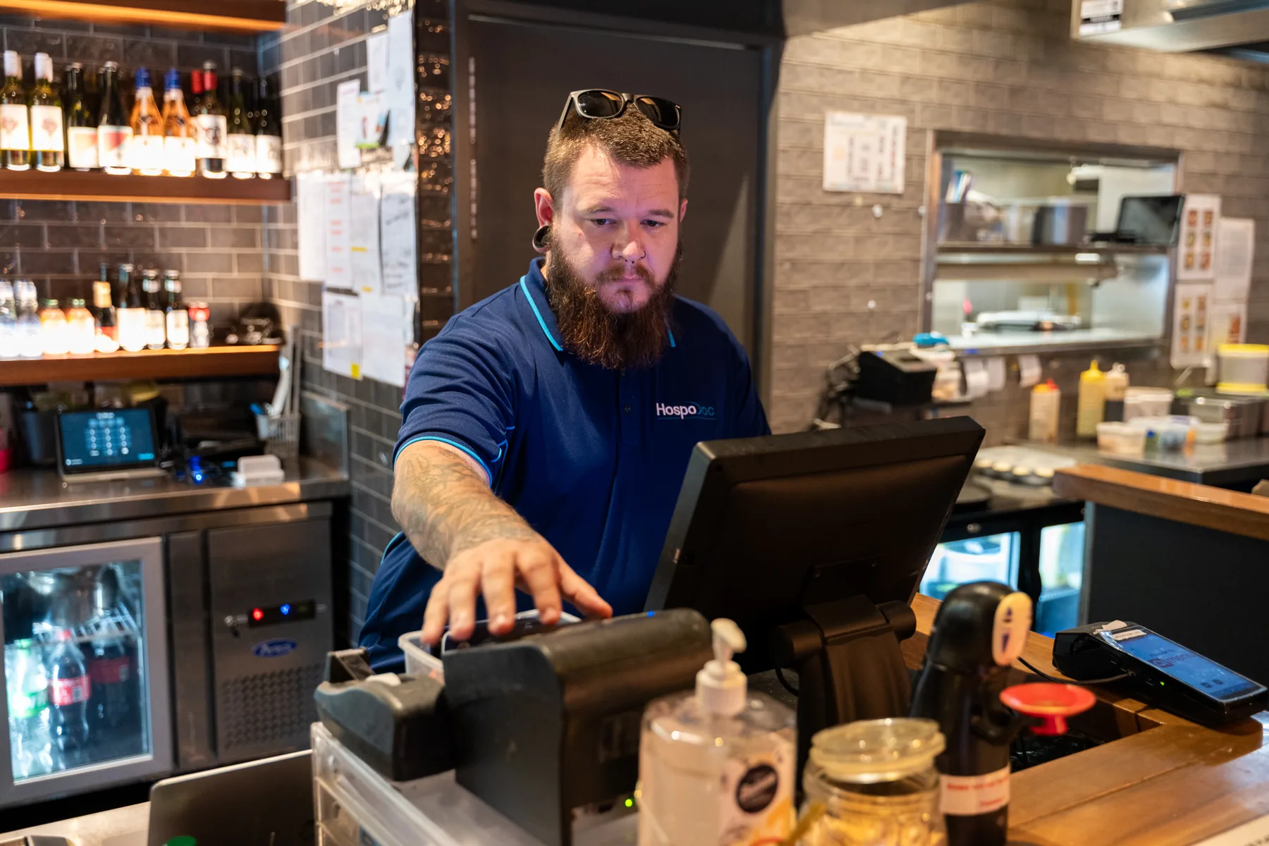 HospoDoc technician working on a point-of-sale system inside a hospitality venue