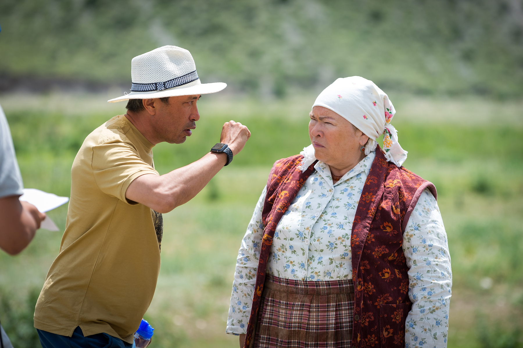 Actor and director working on location with camera track and crew behind them