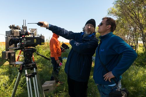 Film crew working beside a cinema camera on location