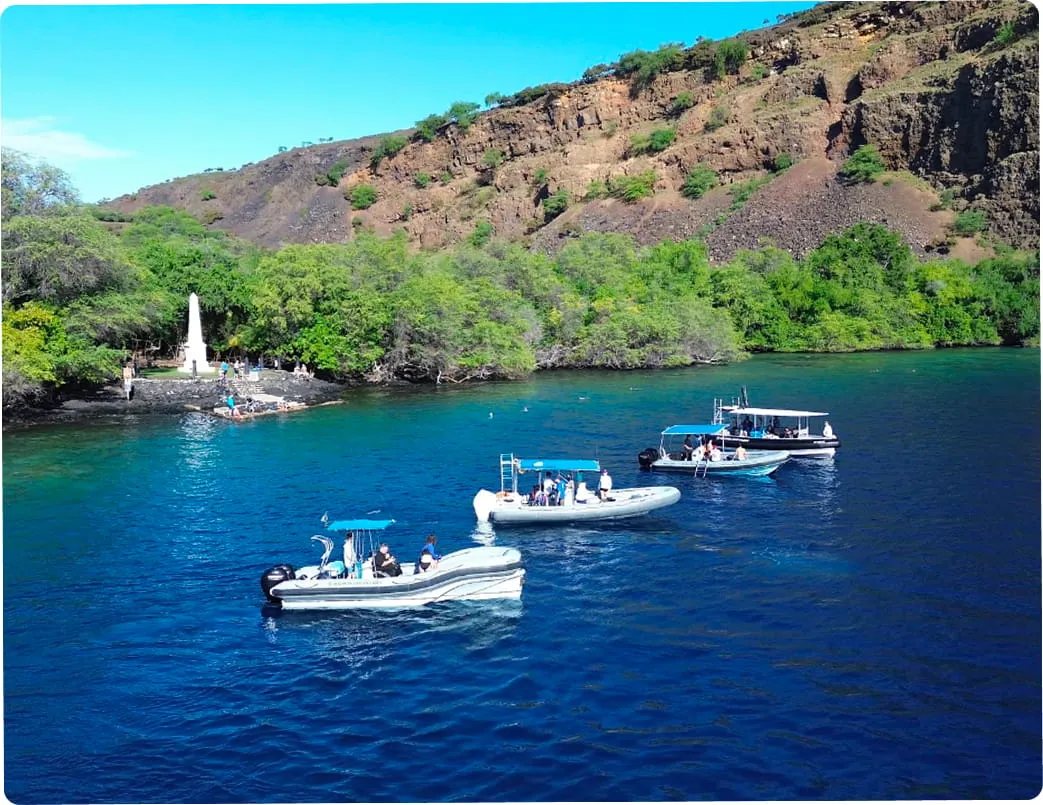 Twin-hull catamaran and classic motor cruiser anchored in calm bay waters Twin-hull catamaran and classic motor cruiser anchored in calm bay waters