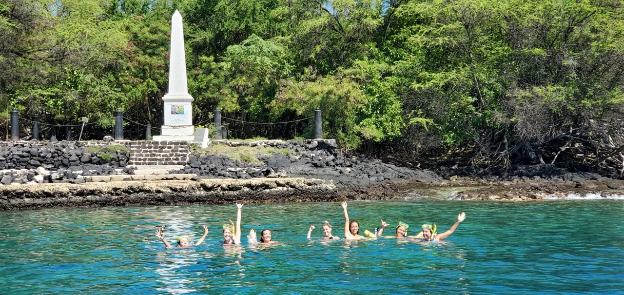 Snorkelers entering clear waters from a small tour boat Snorkelers entering clear waters from a small tour boat
