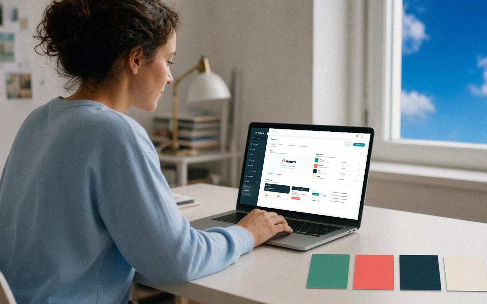 Woman at a laptop with brand colour swatches on the desk