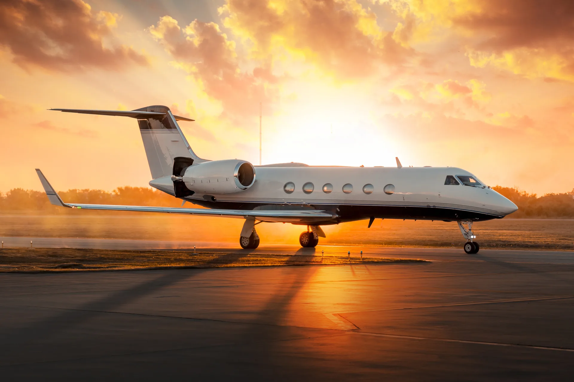 A Gulfstream business jet on the ramp at golden-hour sunset