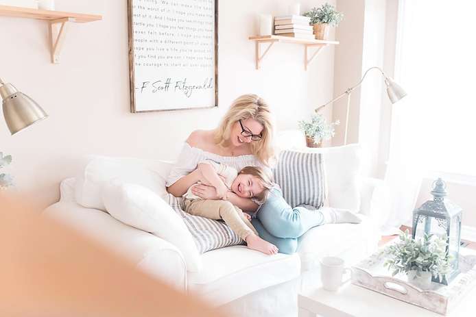 Mother and child enjoying a cozy moment on a white sofa, surrounded by home decor, emphasizing warmth and family connection.