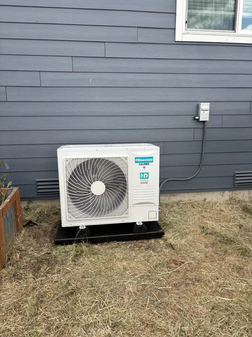 Professional technician checking electrical connections on a heat pump outdoor unit Professional technician checking electrical connections on a heat pump outdoor unit