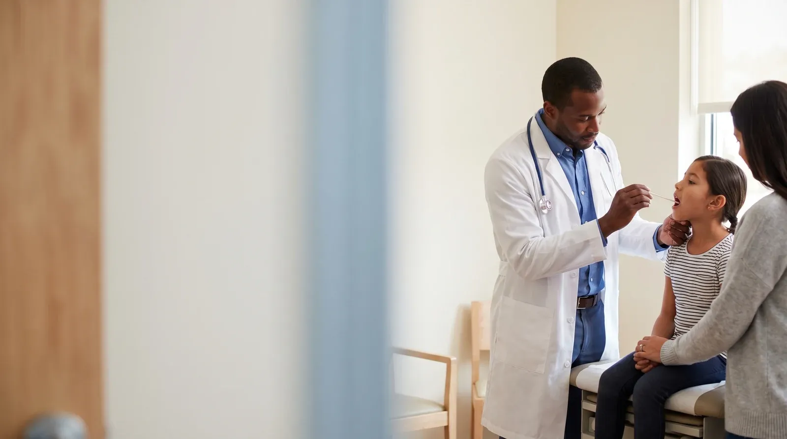 Mother holding child while being seen by a nurse at AllCare urgent care