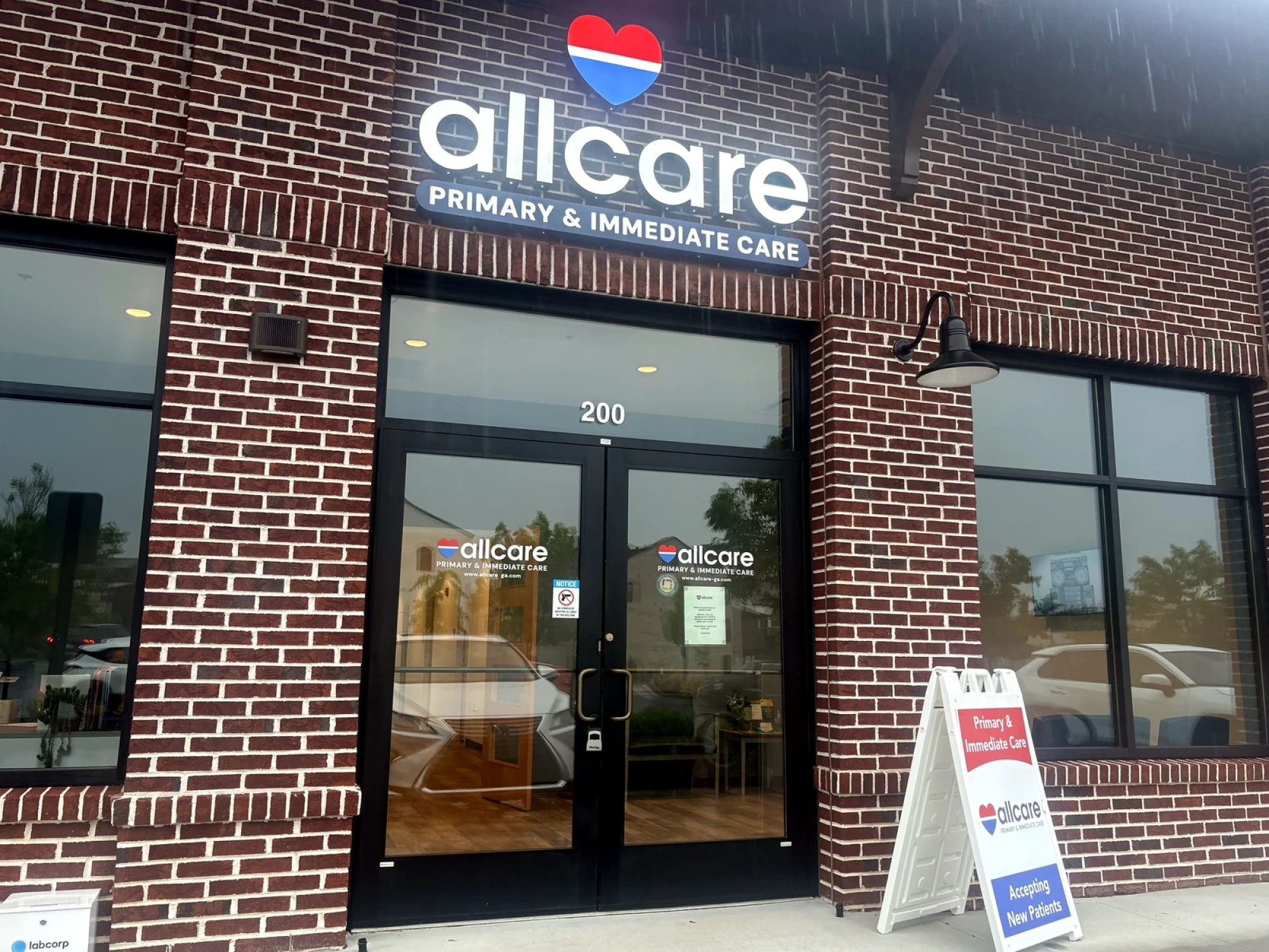 Mother holding child while being seen by a nurse at AllCare urgent care