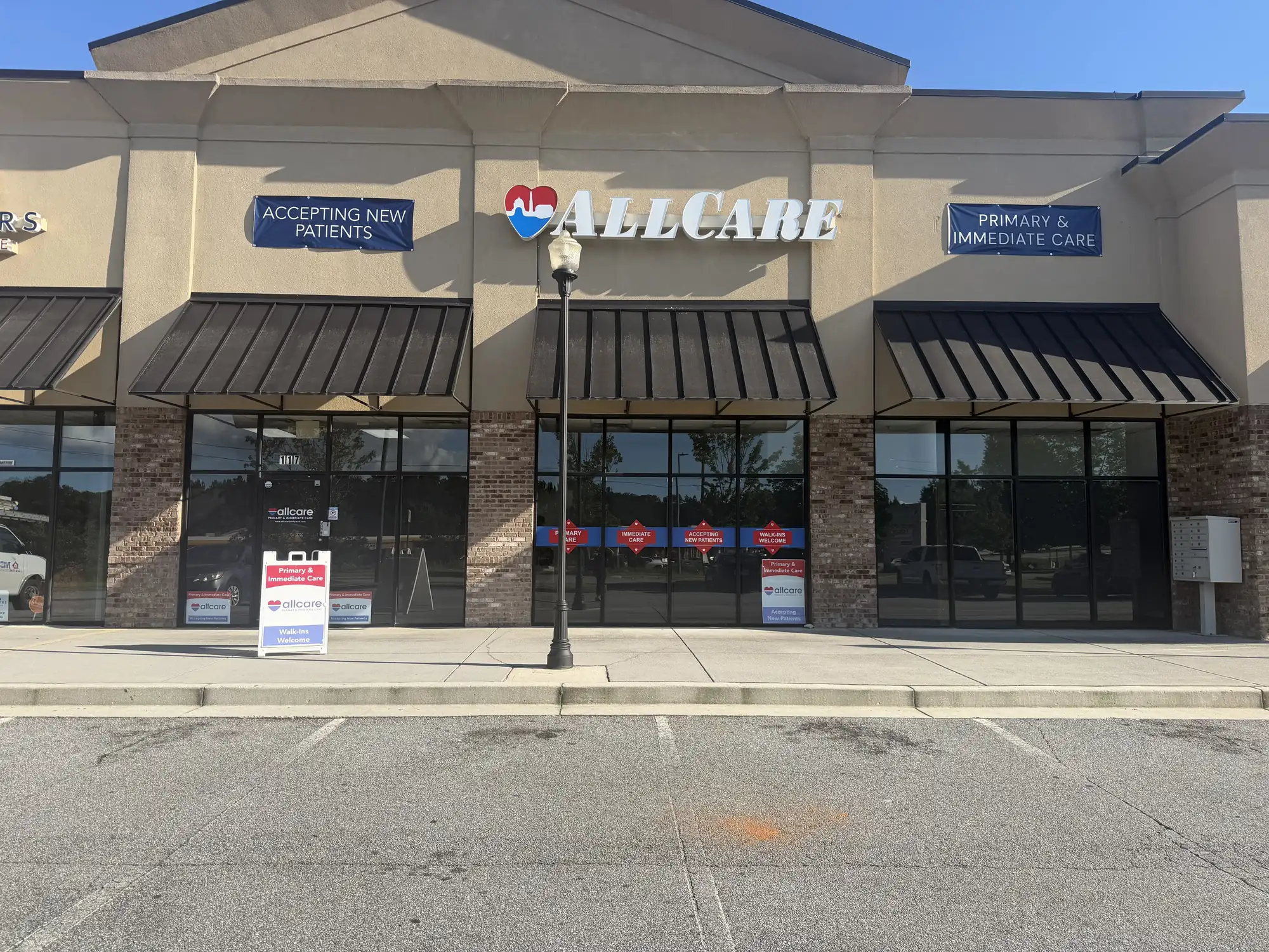 AllCare Dallas clinic exterior, storefront with awnings and Accepting New Patients banners