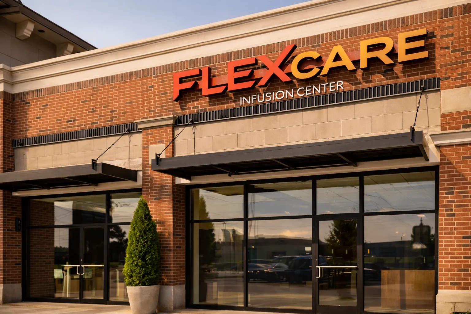 Entrance of FLEXCARE Infusion Center with glass doors and a large green potted plant outside.