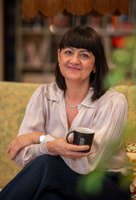 Anja Chirstensen smiler blidt med en kaffekopp i hånden.