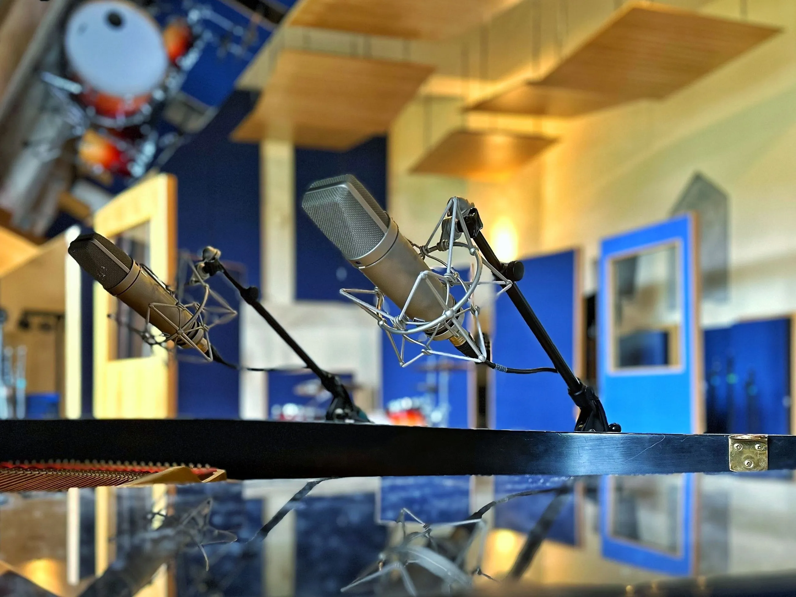 Studio microphones positioned above a piano
